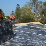 operai su tetto per manutenzione dei pannelli solari per la protezione contro la grandine