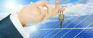 Foto con pannelli solari e una mano che tiene una chiave