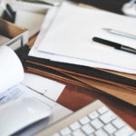 immagine di un tavolo con sopra fogli, plichi, documenti vari