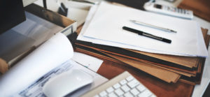 immagine di un tavolo con sopra fogli, plichi, documenti vari