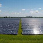 parco fotovoltaico. Distesa di pannelli solari su un prato verde